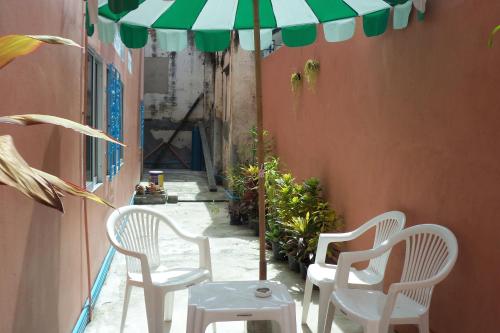 a group of chairs and an umbrella on a patio at D's Corner & Guesthouse in Phuket
