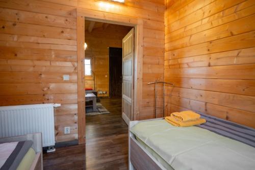 a bedroom with a bed in a wooden wall at Waldsiedlung - Haus 13 in Großkoschen