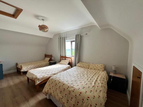 a bedroom with two beds and a window at Large Holiday Apartment Enniscrone in Enniscrone