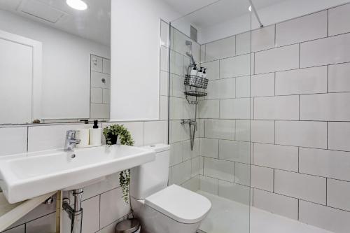 a white bathroom with a sink and a toilet at Oasis Duna _ Estrella Del Mar Pool in Corralejo