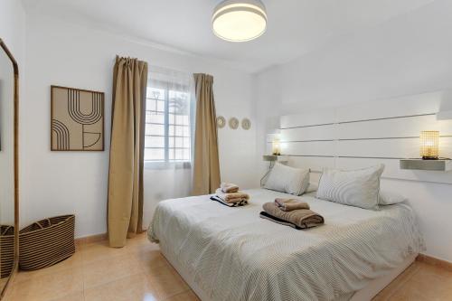 a bedroom with a bed with two towels on it at Oasis Duna _ Estrella Del Mar Pool in Corralejo