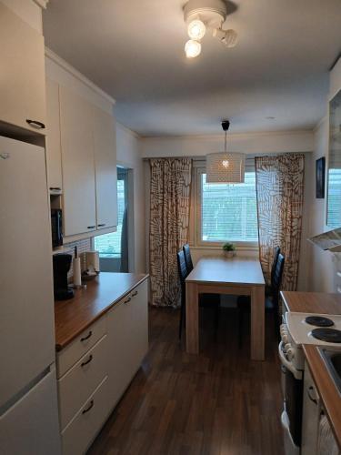 a kitchen with a table and a dining room at Apartment in Raahe