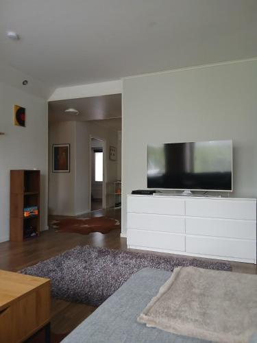 a living room with a flat screen tv on a white entertainment center at Apartment in Raahe