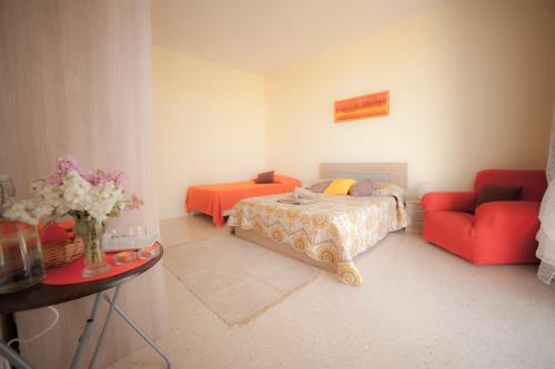 Secco's Seaview Accommodation في Mġarr: غرفة نوم بسرير واريكة حمراء