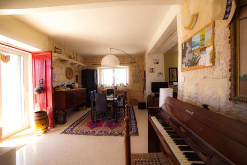 a living room with a table and a piano at Secco's Seaview Accommodation in Mġarr