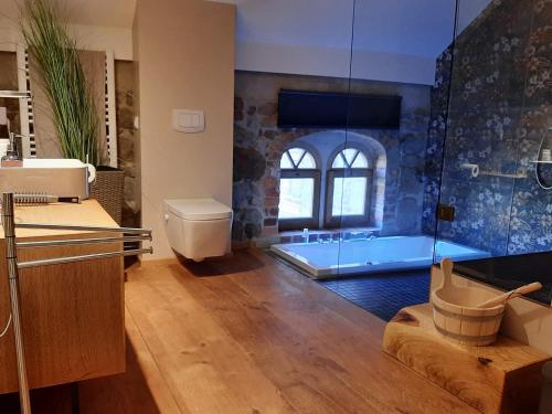 a bathroom with a tub and a glass shower at Stilvolles Wellnes-Refugium mit Privatsauna, Whirlwanne & Kamin im historischen Gut in Großharthau