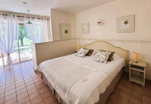 a bedroom with a bed and a large window at La Résidence du Moulin in Tourrettes-sur-Loup