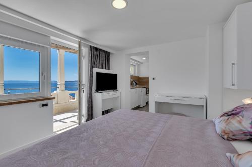 a bedroom with a bed with a view of the ocean at Villa King Apartments in Brela