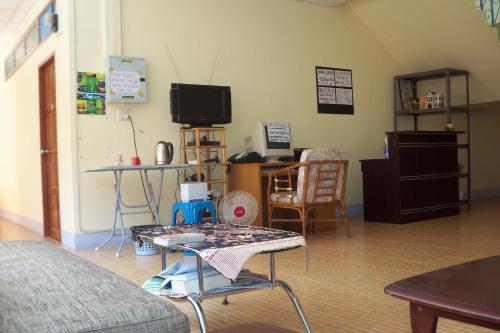 salon ze stołem i telewizorem w obiekcie D's Corner & Guesthouse w Phuket