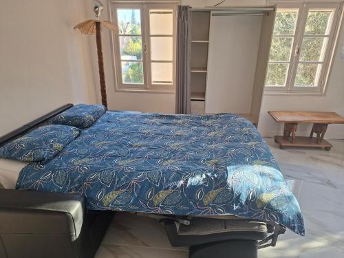 a bedroom with a bed with a blue blanket at comfortable studio in Grasse