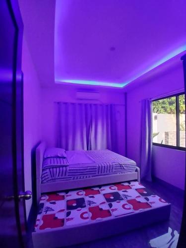 a bedroom with a bed in a purple room at Rams home in Moalboal