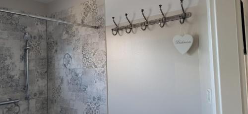 a bathroom with a shower with a heart on the wall at rosmarin-am-sund in Altefähr