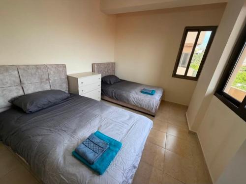 a small bedroom with two beds and a window at Batroun sunset guesthouse in Batroûn