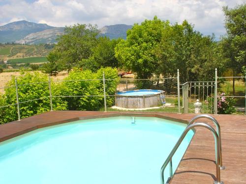 a large swimming pool in a backyard with mountains in the background at Agriturismo "Borgo Madonna degli Angeli" - charming cottages in the gardens ! in Tocco da Casauria