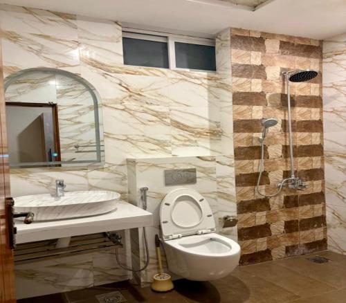 a bathroom with a toilet and a sink and a shower at Fogland Hotel Nathia Gali in Nathia Gali
