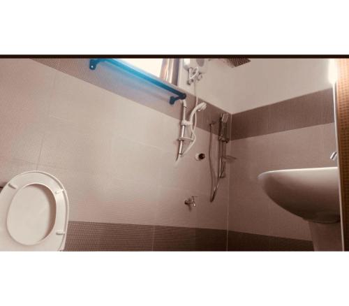 a bathroom with a shower and a toilet and a sink at Cili Hotel & Pizza Restaurant in Arugam Bay