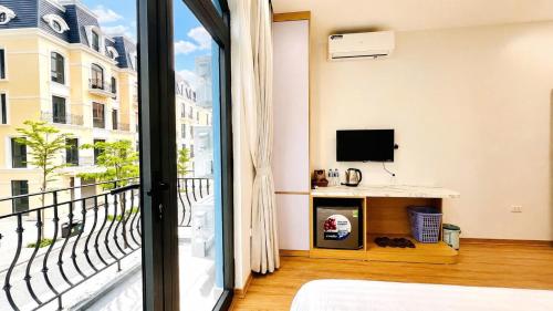 a room with a bed and a tv and a balcony at The Muse Hotel 3 in Ðố Sơn