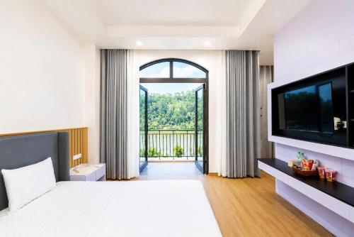 a bedroom with a large bed and a television at The Muse Hotel 3 in Ðố Sơn