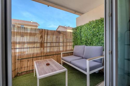 a patio with a chair and a table and a fence at Le Jardin de l'Atrium - Appartement moderne proche de Genève et Palexpo in Saint-Julien-en-Genevois