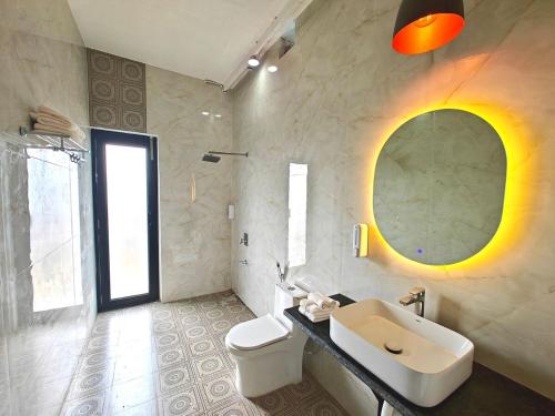 a bathroom with a sink and a toilet and a mirror at Oasis Murthal Open Field Views in Indraprast