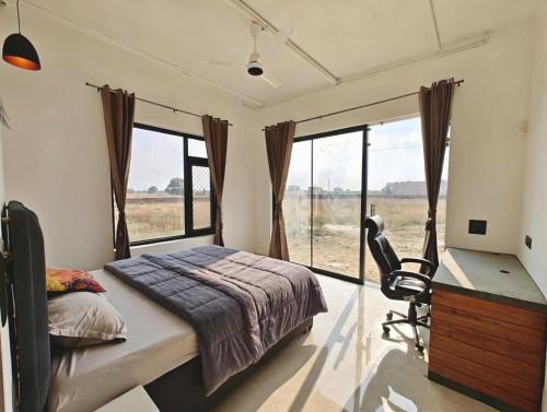 a bedroom with a bed and a desk and window at Oasis Murthal Open Field Views in Indraprast
