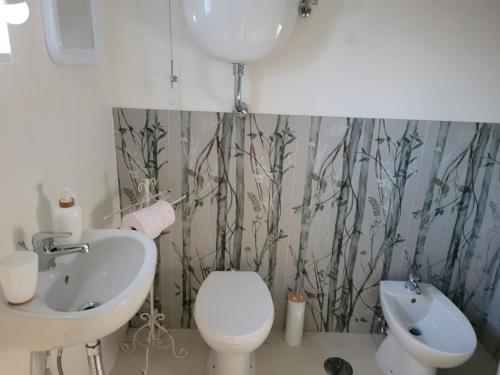 a bathroom with a white toilet and a sink at Il Borghetto in Palinuro