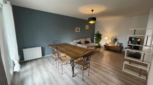 a living room with a table and a couch at Le Pegan - Appartement 2 chambres proche du centre de Ferney et de Palexpo in Ferney-Voltaire