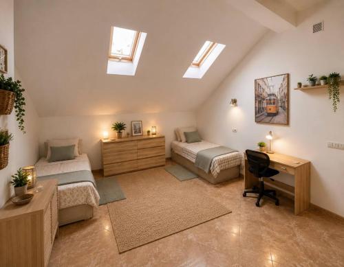a attic bedroom with two beds and a desk at Guesthouse Milagre Centro Faro in Faro