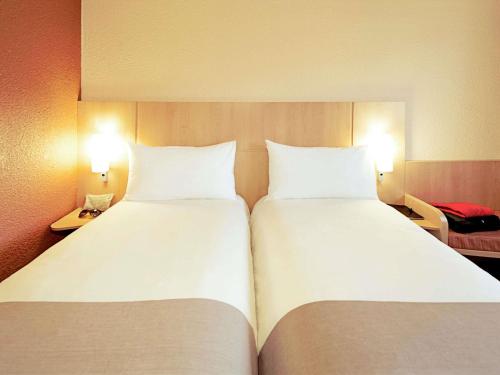 two large white beds in a room with two lamps at ibis Hotel Brussels Expo Atomium in Brussels