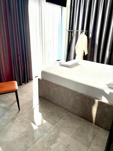 a bedroom with a bed and a chair next to a window at Blue Horizon Apartments in Ureki