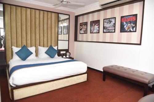 a bedroom with a bed and a bench in it at Belair Suites in Pune