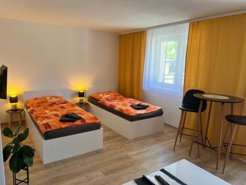a bedroom with two beds and a table and chairs at Vilka Čachtice in Čachtice