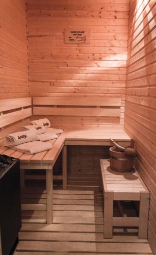 a sauna with a bench and a bucket in it at StrandBerg's Harzchalet in Braunlage