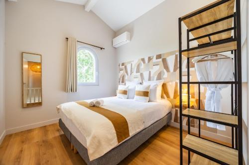 a bedroom with a king sized bed with a ladder at La Maison Blanche in Saint-Sulpice-de-Faleyrens