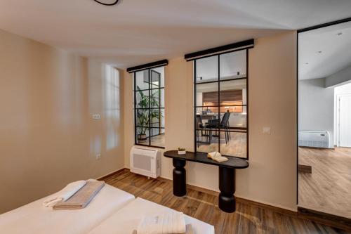 a room with a bed and a table and windows at La VILLA DELLE TORRI in Ermoupoli