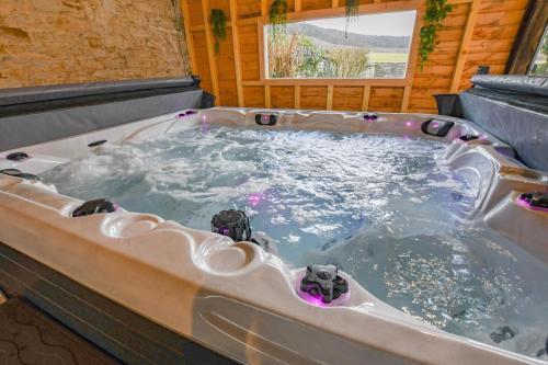 a jacuzzi tub in a room with a window at Le clos embelli in Rouvres-les-Vignes