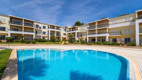 a swimming pool in front of an apartment building at Clube Alvor Ria - Prime Residence in Alvor