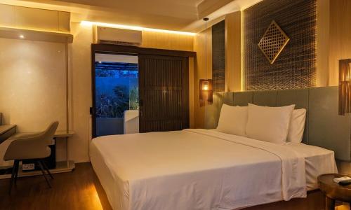 a bedroom with a large white bed in a room at Merumatta Senggigi Lombok in Senggigi
