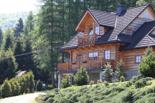 a log house with a balcony on a hill at Mosorny Park Zawoja Całoroczne domki w górach in Zawoja