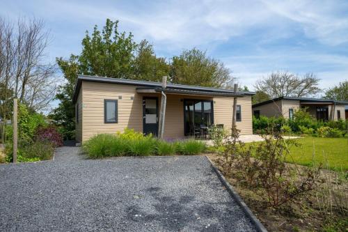 a house with a gravel driveway in front of it at EuroParcs Markermeer in Bovenkarspel