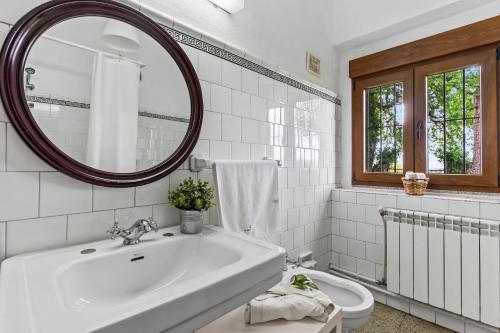a white bathroom with a sink and a mirror at La casona de La Garaba in Grado
