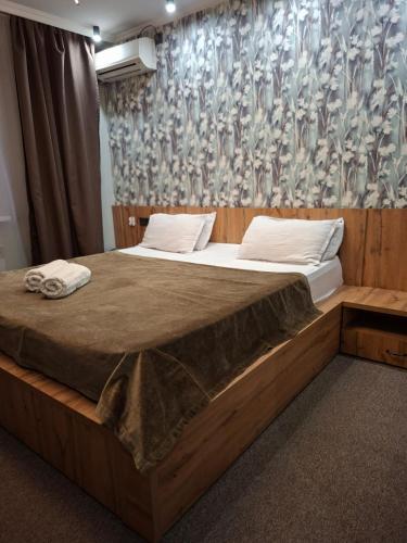 a bedroom with a large wooden bed with a curtain at Hotel Mardin in Almaty