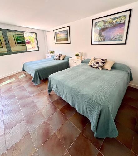 two beds in a room with tile floors at Gandia Confort Treviso in Gandía
