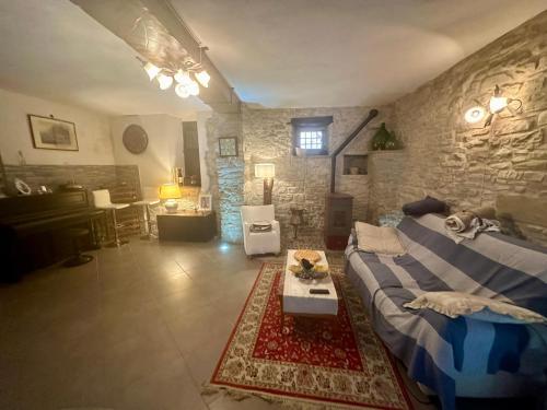 a living room with a couch and a stone wall at Casa San Francesco in Agnone
