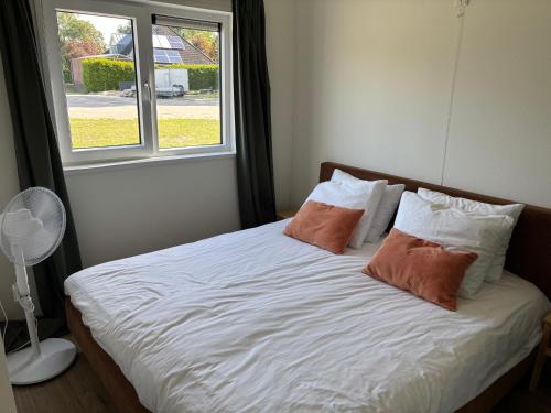 a bedroom with a bed with two pillows and a window at Boerenlodge in Bruchterveld