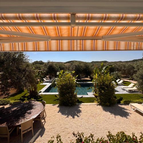 a patio with a table and a swimming pool at Alaçatı Beka House in Alaçatı
