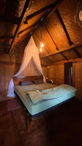 a bedroom with a bed with a net on it at Tetebatu Cabin Hut in Tetebatu