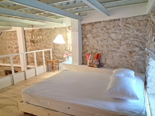 a bed in a room with a stone wall at Sea & Sun in Gialova