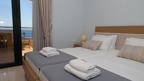 a bedroom with two beds with towels on them at Villa Thea, By IdealStay Experience in Kaloi Limenes