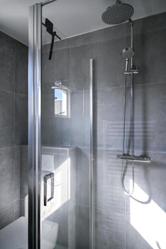 a shower with a glass door in a bathroom at Waddenhuyske in Hollum
